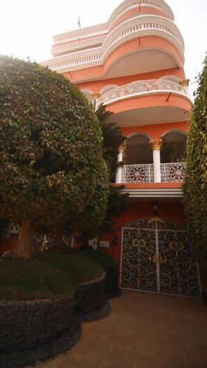 A building with a curved facade, ornate balconies, and a gated entrance. - Hotel Illiyin (Dakar)
