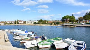 A marina with several boats docked, a clear sky, and buildings in the background. - Apartment Eva in Zambratija-Savudrija, air-conditioned, close to the beach (Umag/ Zambratija)