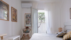 Une chambre à coucher avec un lit, un bureau, une chaise et une fenêtre avec des rideaux.