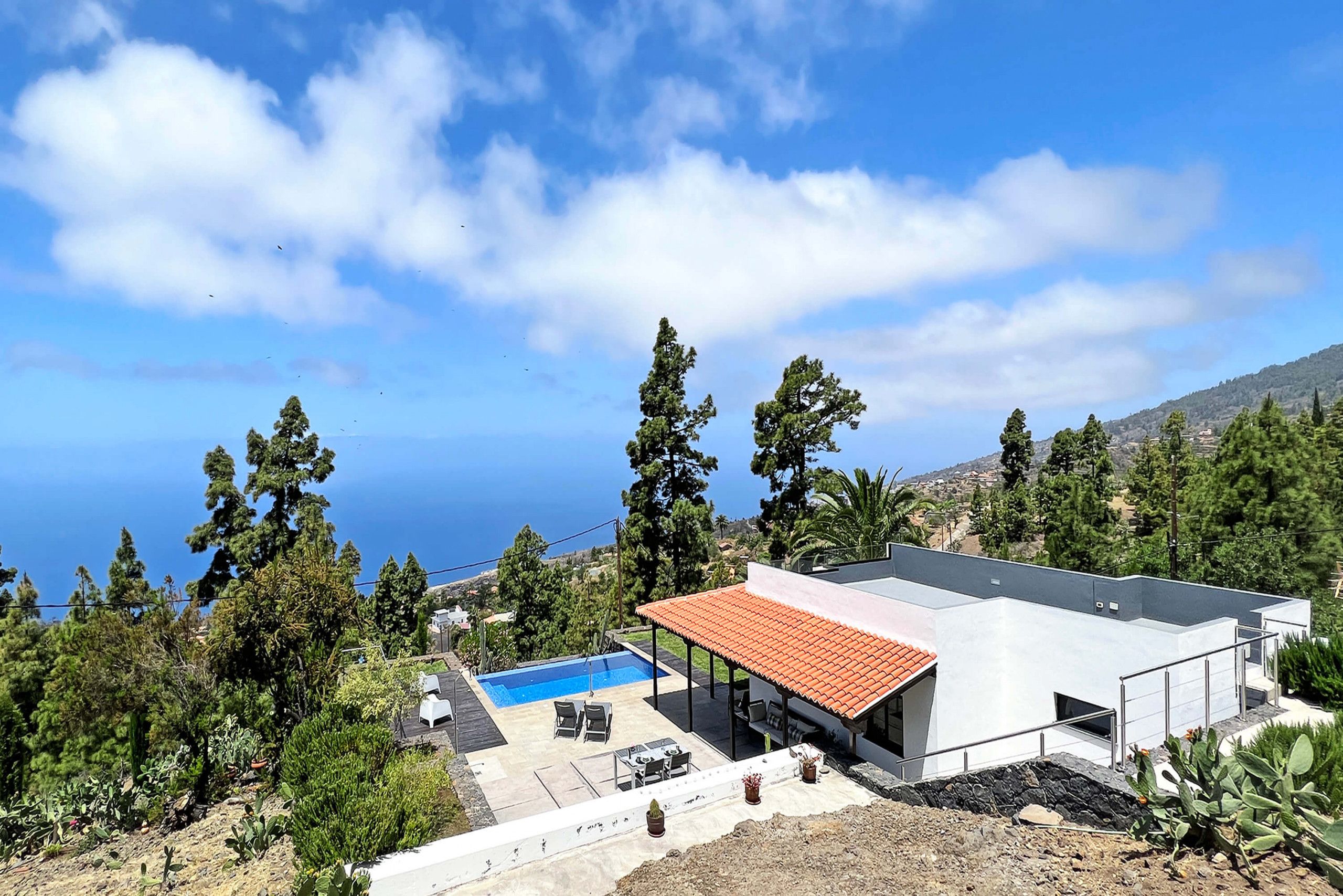 Uma villa moderna com piscina, área de estar externa e vista para o mar.
