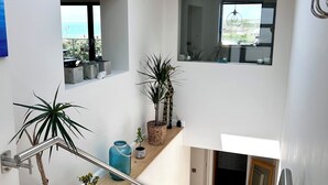 Een modern interieur met dakraam, wenteltrap en potplanten.
