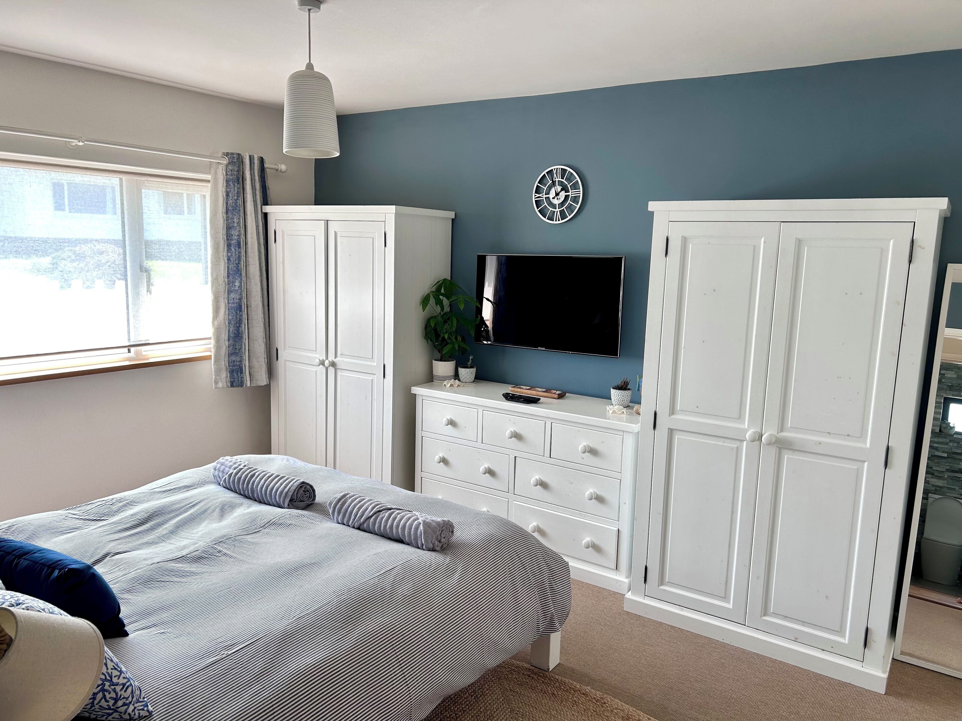 Une chambre à coucher avec un lit, une télévision et une armoire.