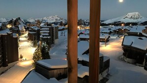 A snowy village with buildings and a mountain in the background.