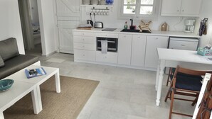 Ett modernt kök med vita skåp, en inbyggd ugn och ett fönster ovanför diskbänken.