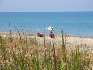 A beach with tall grass in the foreground and a clear view of the sea in the background. - Direct access to the Sea, ideal for family and group, submerged by nature, cosy (Cefalu)