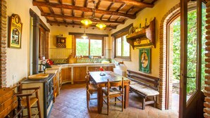 A rustic kitchen with wooden beams, a large island, and a dining area with benches.