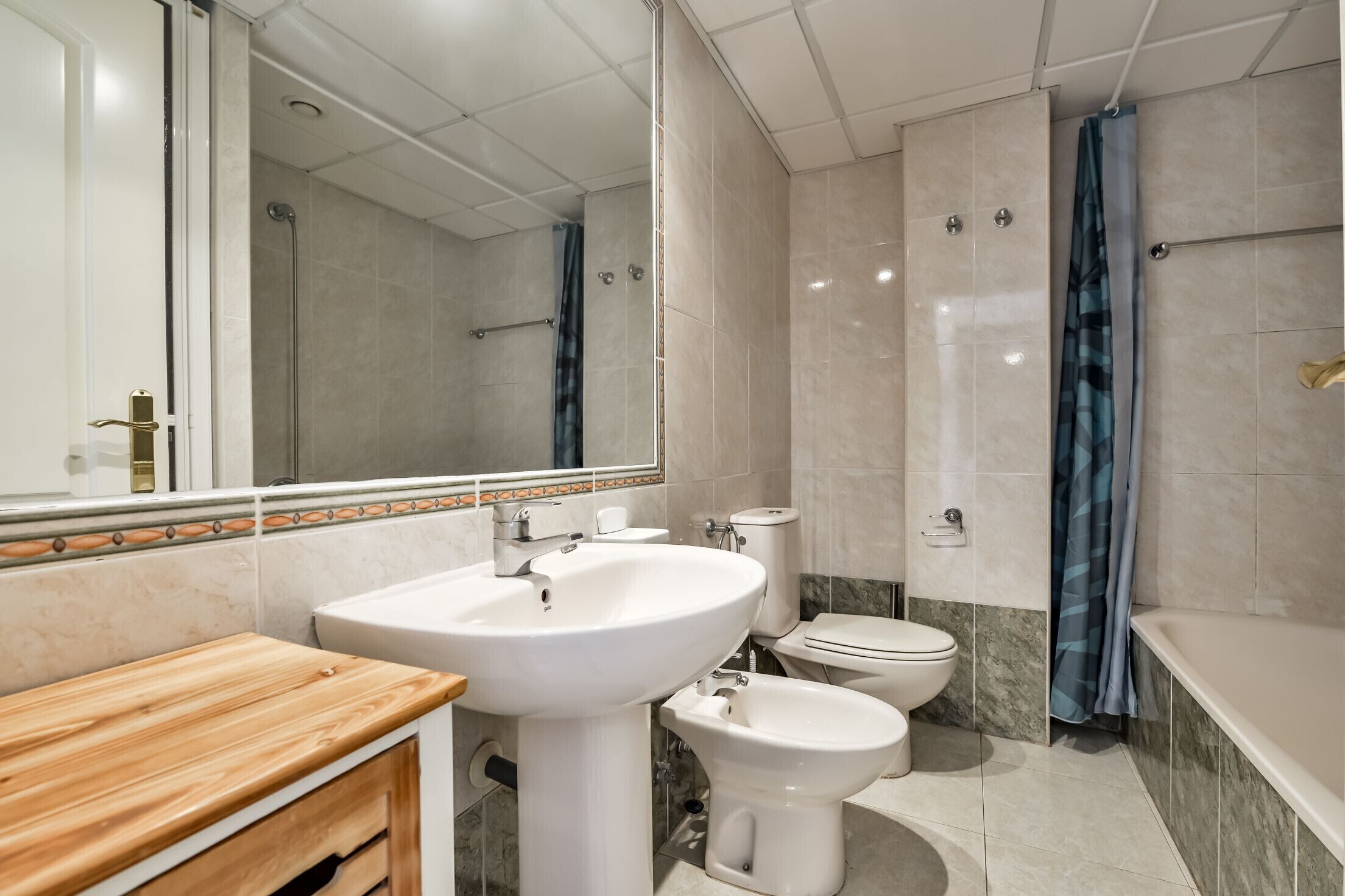 A modern bathroom with a sink, toilet, and bathtub.