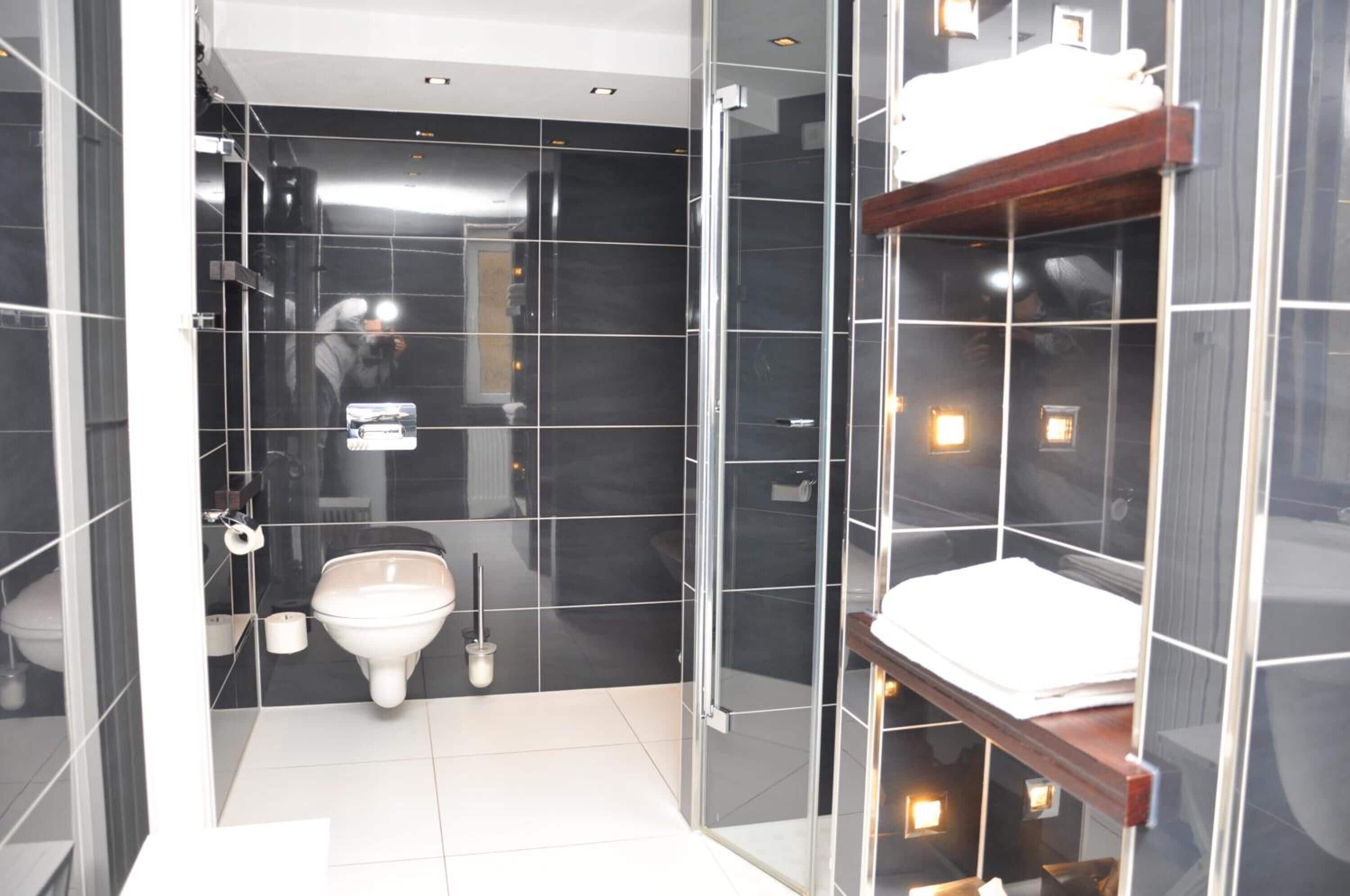 Ein modernes Badezimmer mit Glasdusche, Toilette und Waschbecken.