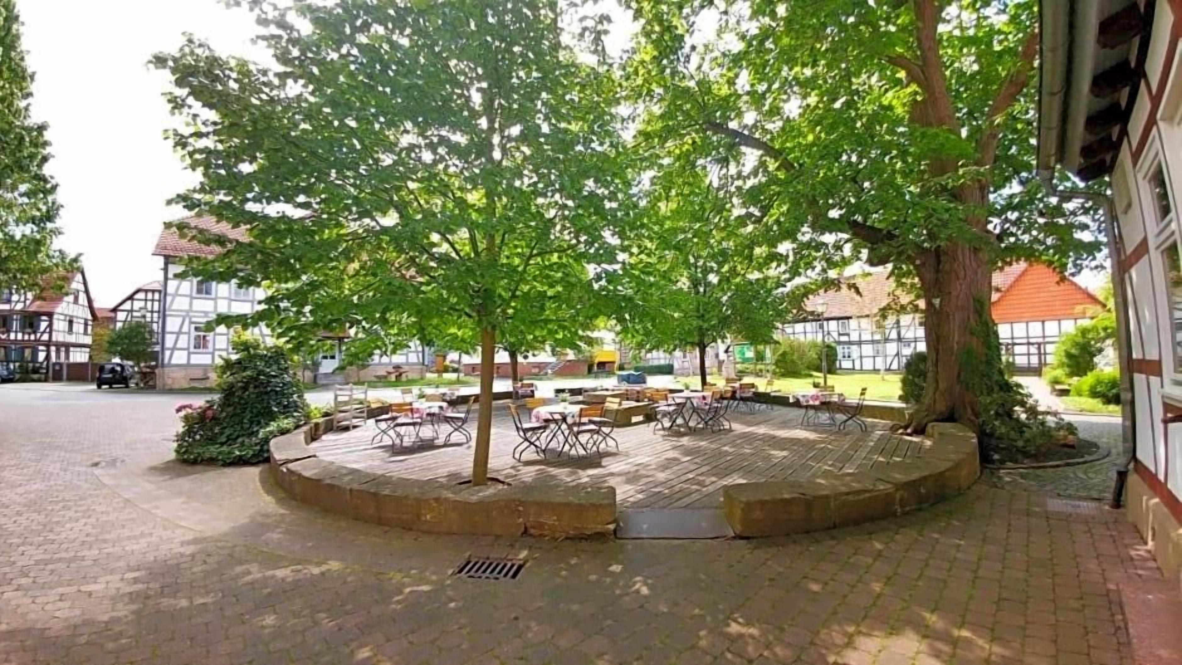 A paved courtyard with outdoor seating and trees.
