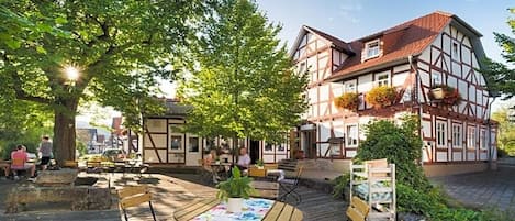 A traditional half-timbered building with outdoor seating and a garden area.