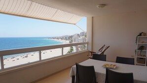 A balcony with a view of the beach and cityscape.