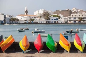 A harbor with boats and colorful canopies.