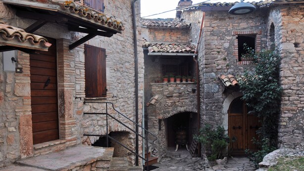 A narrow stone courtyard with a wooden door, a small staircase, and a tiled roof. - CASA LA TORRE in the small Umbrian village of Macerino (Acquasparta)