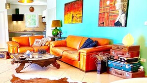 Un salón con sofá, mesa de centro y alfombra de cuero de vaca.