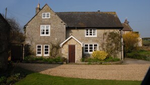 A stone house with a gravel driveway and a small garden. - The Granary at French Mill: charming cottage set in extensive garden with stream (Sandford, Isle of Wight)
