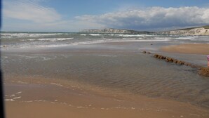 A beach with white cliffs in the background and a sandy shore. - The Granary at French Mill: charming cottage set in extensive garden with stream (Sandford, Isle of Wight)