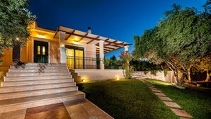 A modern house with a well-lit entrance, a paved driveway, and a neatly trimmed lawn. - Private pool ★ Sea view ★ Wifi ★ Beach at 1km ★ 3 bedrooms (Galatas)