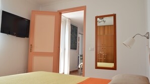 A bedroom with a bed, a television, a mirror, and a lamp. - AMALFI COAST HOUSE DREAM VACATION (Conca dei Marini)