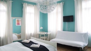 A hotel room with two beds, a desk, a chair, a TV, and a ceiling light fixture. - Hemingway's Hostel Heidelberg (Heidelberg)
