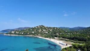 Une ville côtière avec des bâtiments construits sur une colline, dominant une mer bleue et limpide.