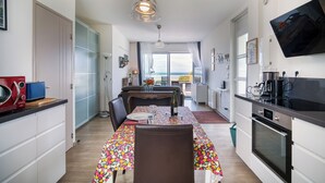 A modern kitchen with a dining area, a view to the sea, and a large window. - Duplex apartment with large terrace facing the sea (plomodiern)