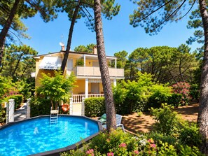 A two-story building with a swimming pool, surrounded by lush greenery and trees. - Villa LIDIA with private pools 90 meters from the beach (Marina di Castagneto Carducci)
