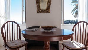 Una mesa de comedor con dos sillas, un cuenco decorativo y un espejo en la pared.