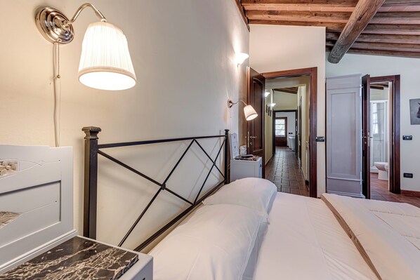 Un dormitorio con cama, mesitas de noche y lámparas de pared.