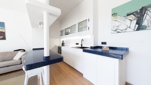 Een moderne keuken met witte kasten, een zwart aanrecht en een inbouwoven.