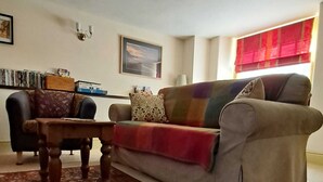 Una sala de estar con un sofá, una mesa de centro y un tapete estampado.