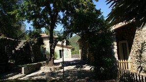 A stone building with a wooden door and a stone staircase leading up to a balcony. - House with character in the Countryside/mountain - 6 bedrooms - Cevennes/Gard (Soudorgues)