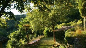 A rustic outdoor setting with a wooden pergola, a dining table, and a stone wall. - House with character in the Countryside/mountain - 6 bedrooms - Cevennes/Gard (Soudorgues)