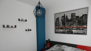 A modern bedroom with a cityscape view, a geometric light fixture, and a neatly arranged bedside table. - Wonderful apartment in Bahía del Duque - Pool, 2 Terraces, Wifi ... (Costa Adeje)