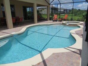 A swimming pool with a tiled deck, surrounded by chairs and a covered patio area. - Beautiful Spacious Gated Modern Luxury Villa Overlooking Conservation Area 7BD6B (Davenport)