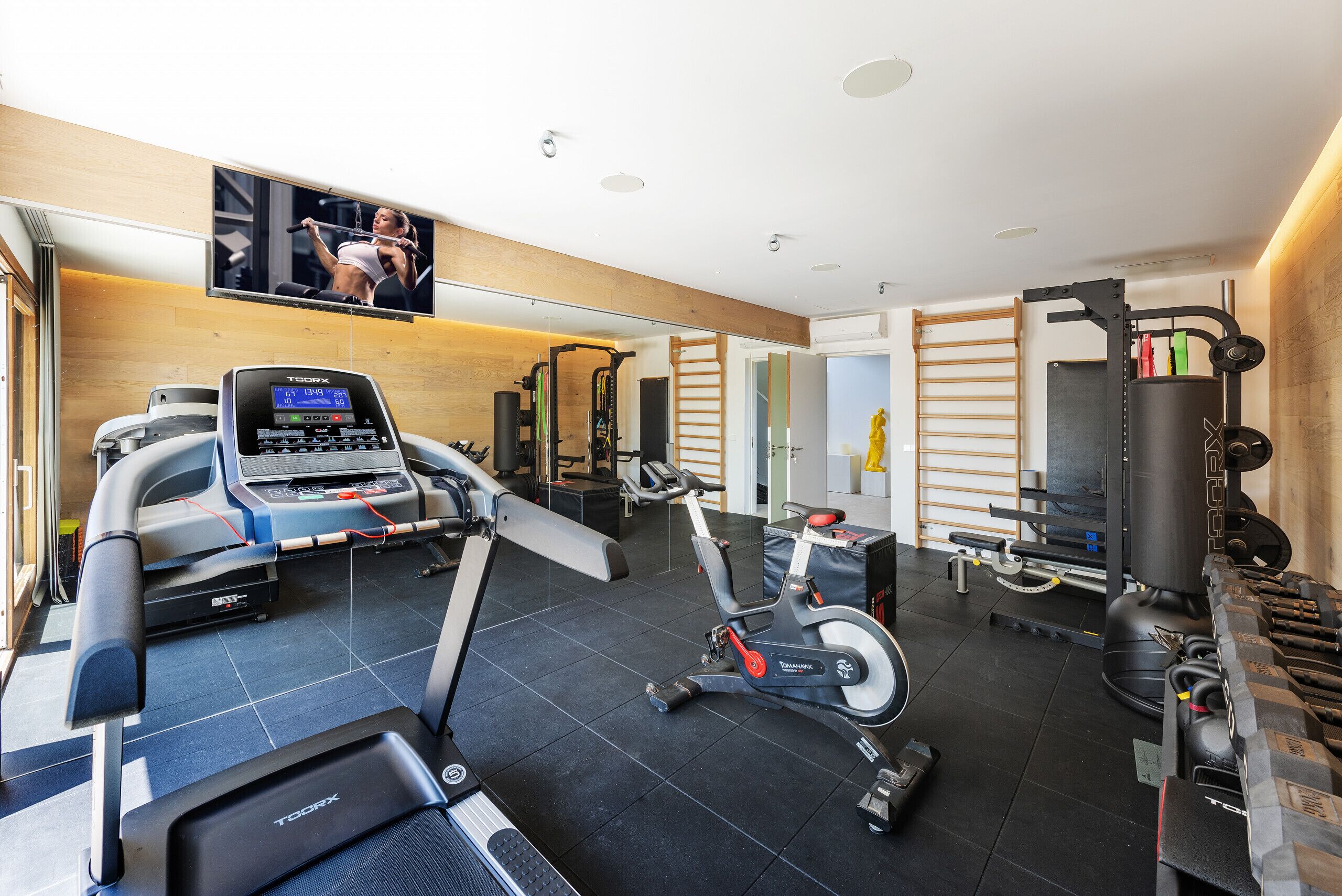 Ein modernes Fitnessstudio mit Laufband, Ergometer und Gewichten.