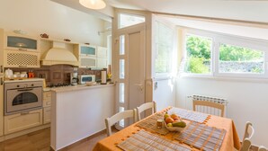 A kitchen with a dining area, featuring a stove, microwave, and cabinets.