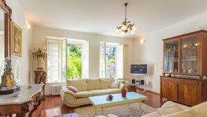 A living room with a beige sofa, a coffee table, a wooden cabinet, and a television.