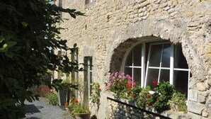 A stone building with a window and potted plants. - Karen House 5mn Omaha Beach DDay in Aure-sur-mer (Aure sur Mer)