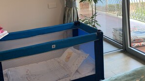 Una habitación con ventana, cortina, planta y una alberca pequeña.