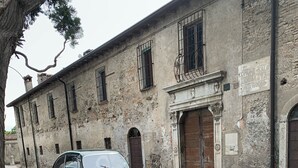 Un coche verde antiguo estacionado en una calle con un edificio histórico al fondo.