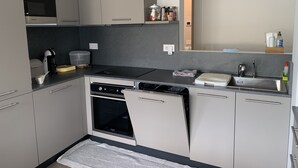 Una cocina compacta con horno integrado, lavavajillas y una pequeña zona de encimera.