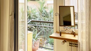 A room with a sliding glass door leading to a balcony with potted plants and a view of a building. - Relaxation in Rome away from the chaos - balcony, light and easy parking (Roma , Monte Sacro)