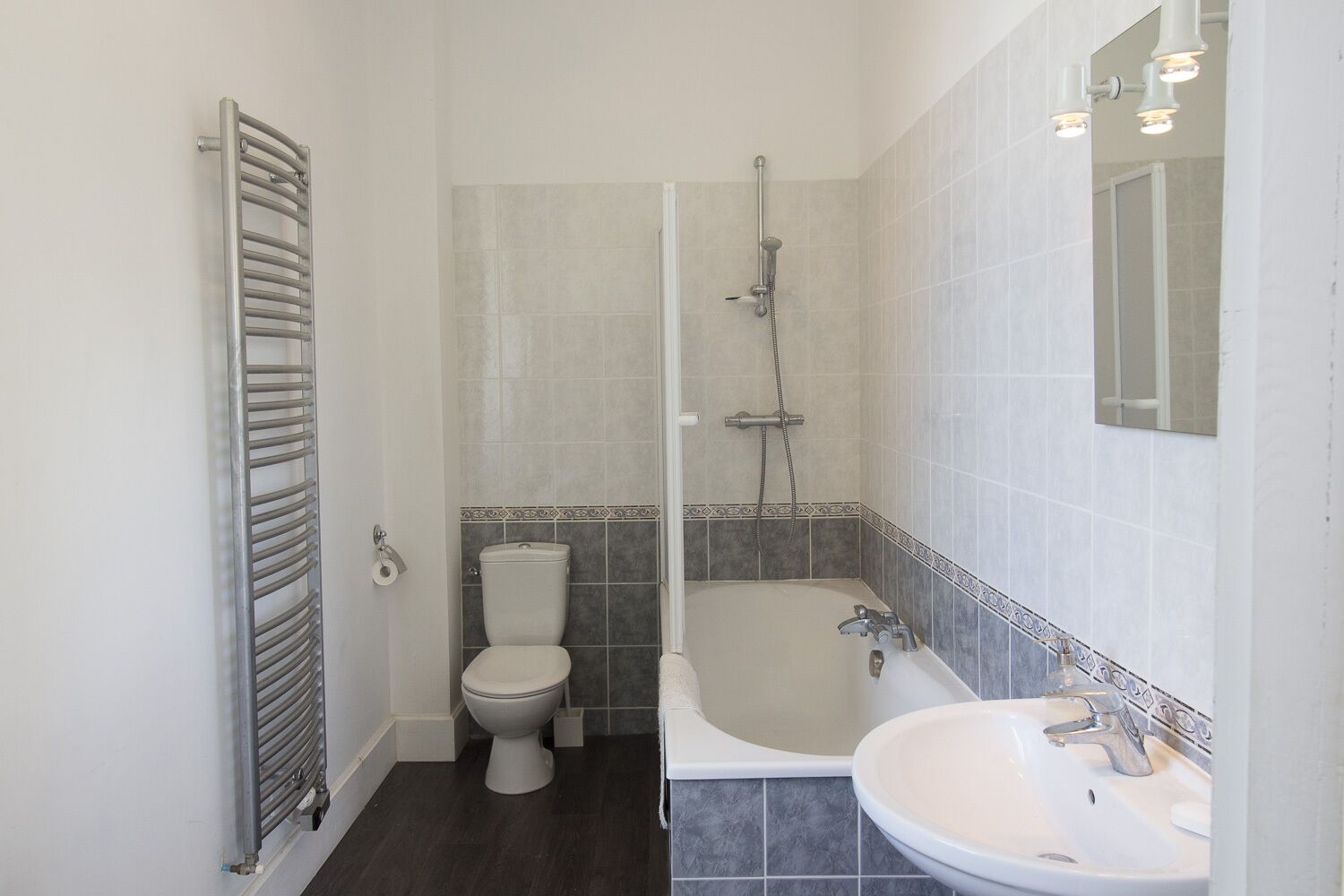 A bathroom with a toilet, a shower, and a sink.