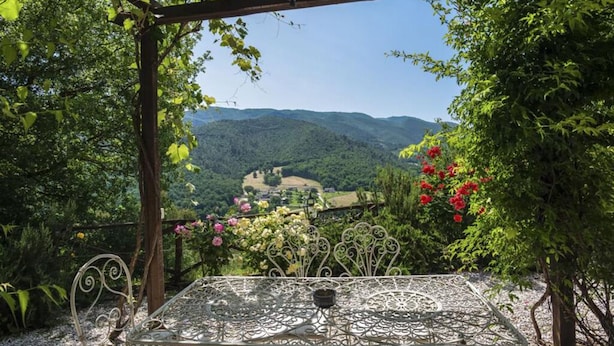 Ein Tisch unter einer Pergola mit Blick auf ein Tal.