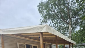 A wooden deck with a covered porch, a picnic table, and a small step leading to the deck. - Mobile home 6 sleeps 4 * Domaine in the heart of the Loire Valley Castles  (Veuzain-Sur-Loire)