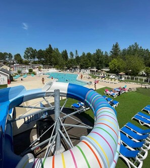 A water slide with a pool area, lounge chairs, and a clear sky. - Mobile home 6 sleeps 4 * Domaine in the heart of the Loire Valley Castles  (Veuzain-Sur-Loire)