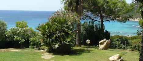 Un jardín con un sendero de piedra que lleva a una vista del mar.