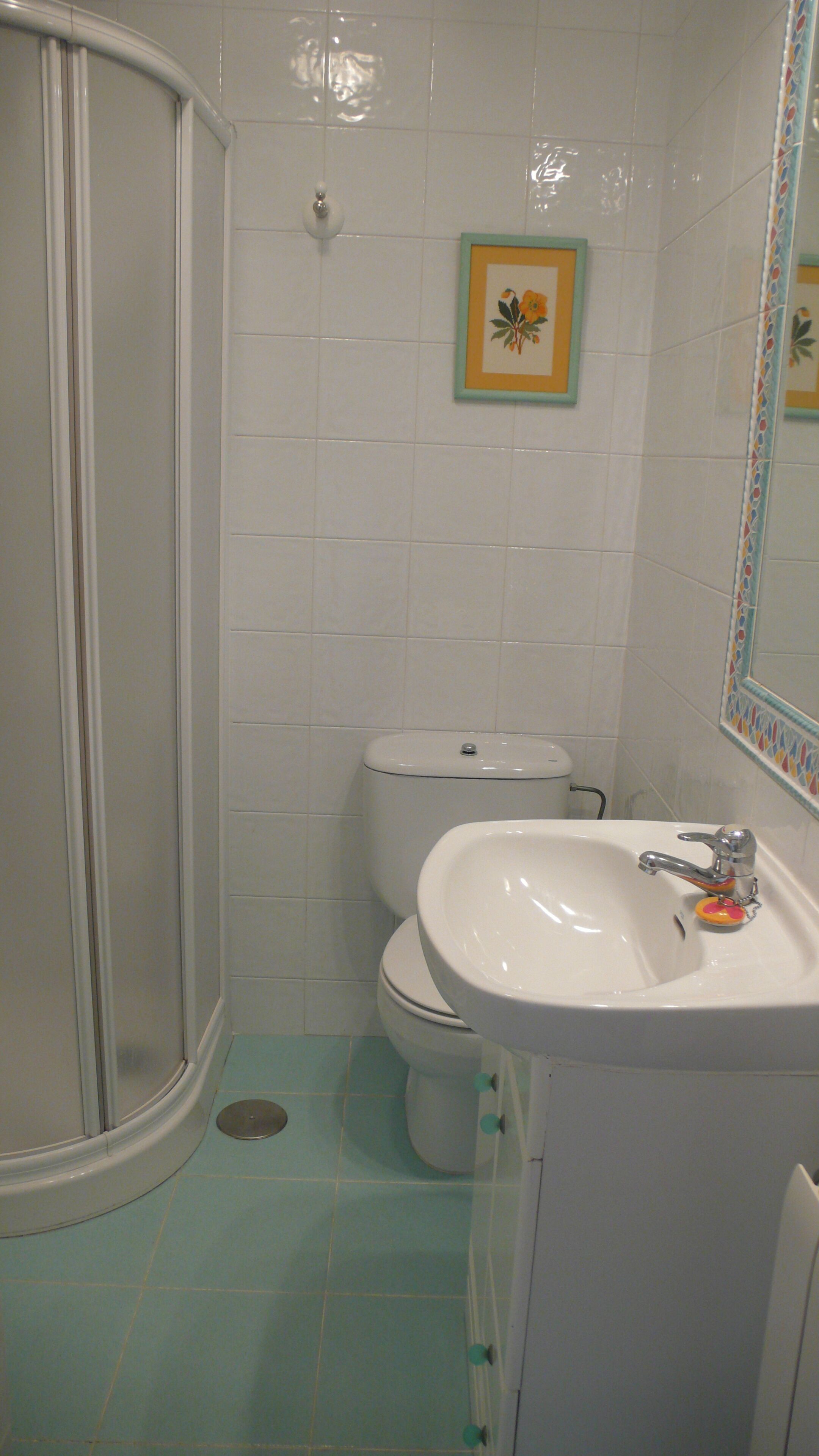 A bathroom with a shower, toilet, and sink.