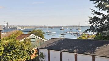 A marina with boats, a lighthouse, and a building with a garage.