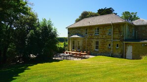 A stone building with a large lawn and outdoor seating area. - MANOR ON COAST WITH SEA VIEWS, TENNIS COURT, BIG GAMES ROOM + BAR, GARDENS (Ventnor)